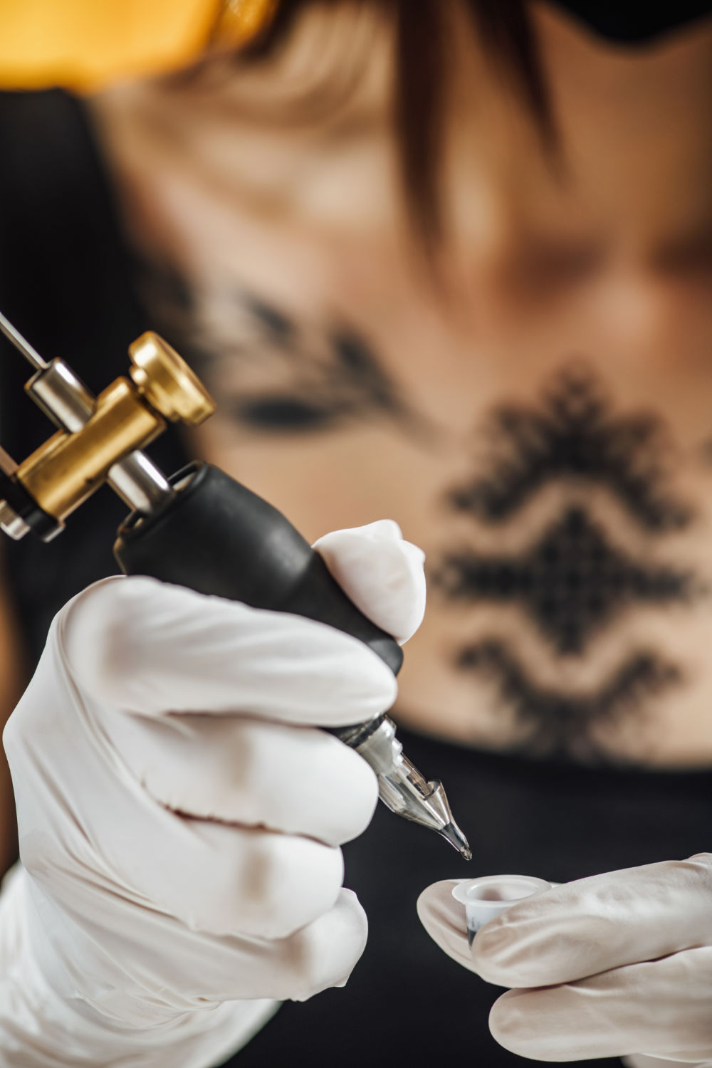 female-tattoo-artist-prepares-tattoo-machine-for-m